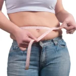 A woman measuring their waist get treat weight loss treatment in Salem, NH at JSJ Aesthetics