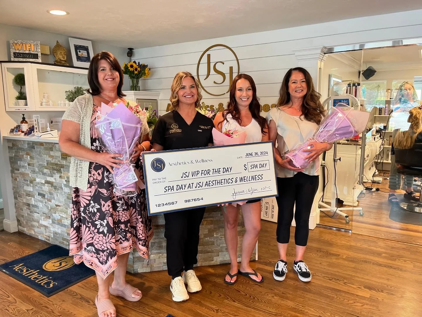 a group of women holding flowers and a check