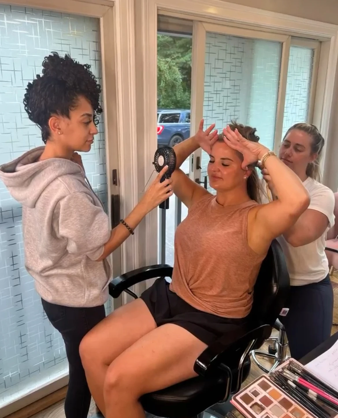 a woman sitting in a chair with a hair dryer