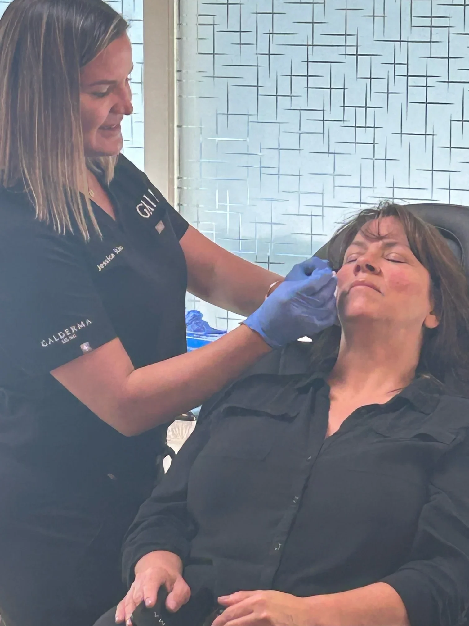 a woman getting a tattoo on her face