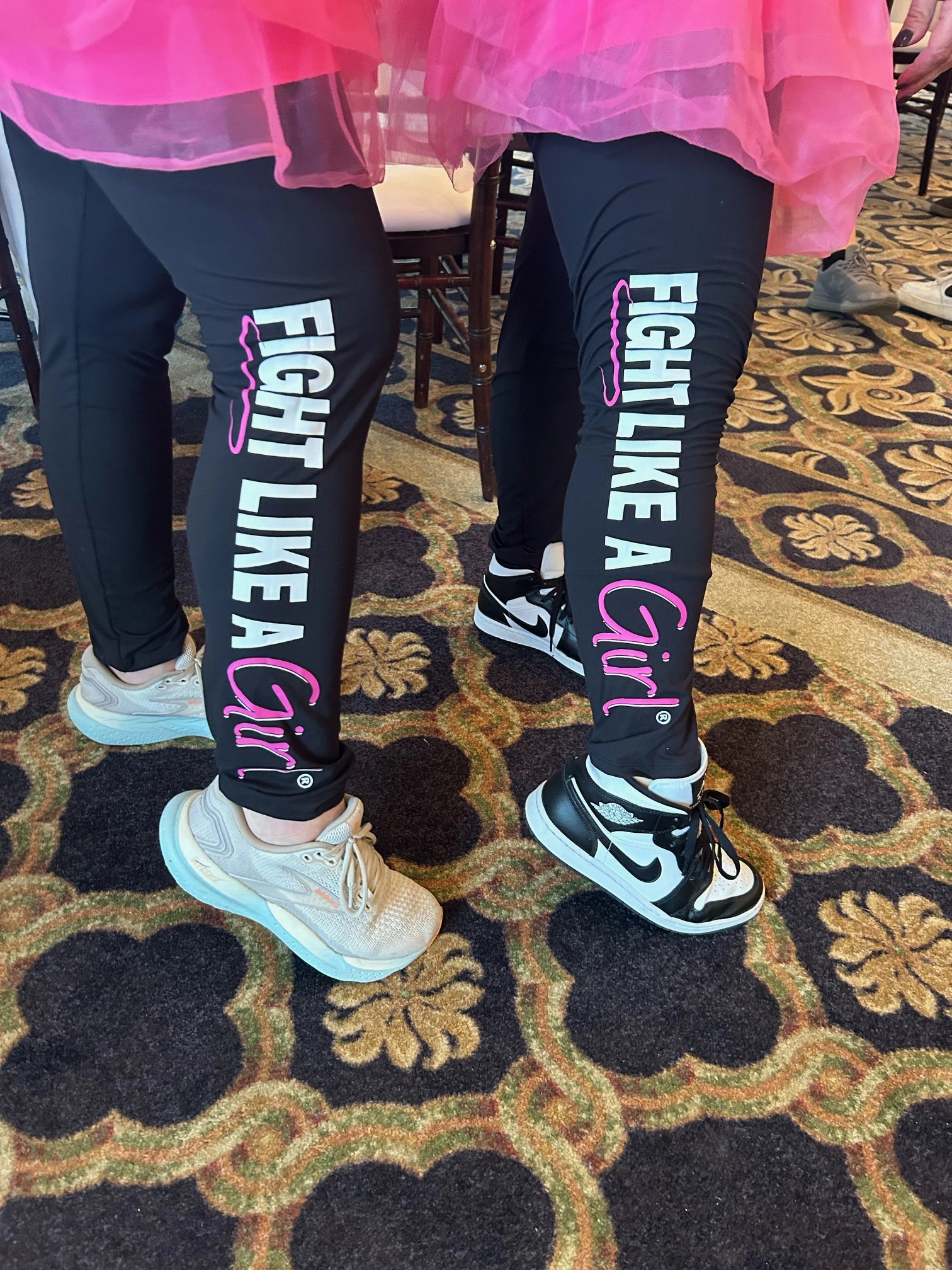 a pair of women's legs wearing black pants with white text