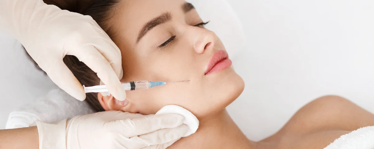 Woman receiving a Botox injection treatment in Salem, NH in her cheek from a medical professional