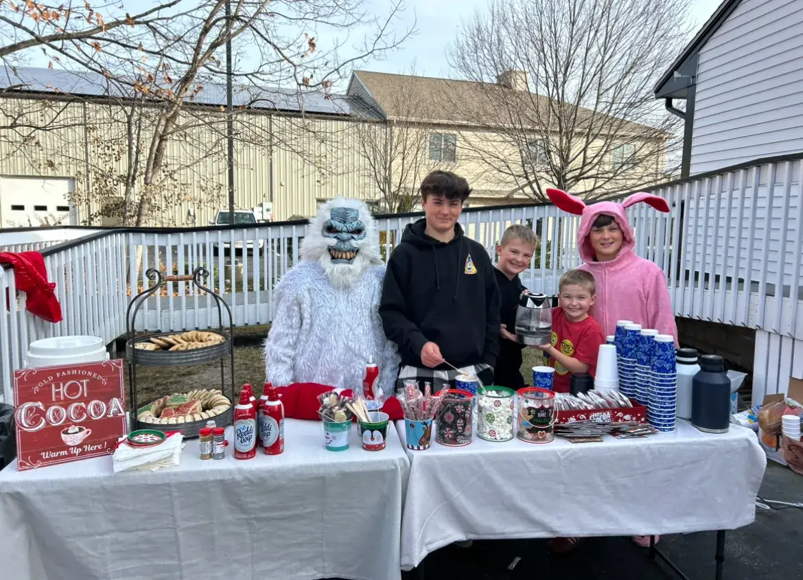 a group of people in garment standing next to a table with food